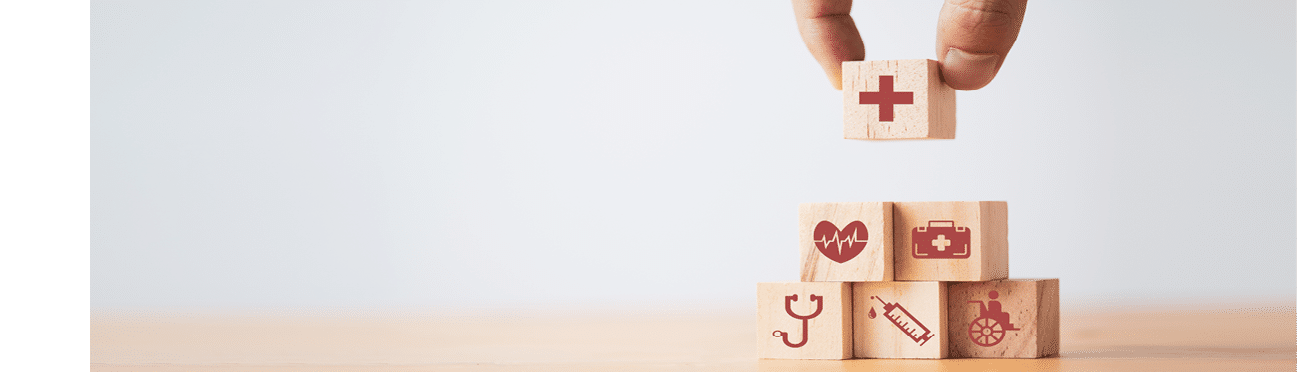 Doctor putting and stacking wooden block cube which print screen health care and medical icons for healthy and wellness concept.